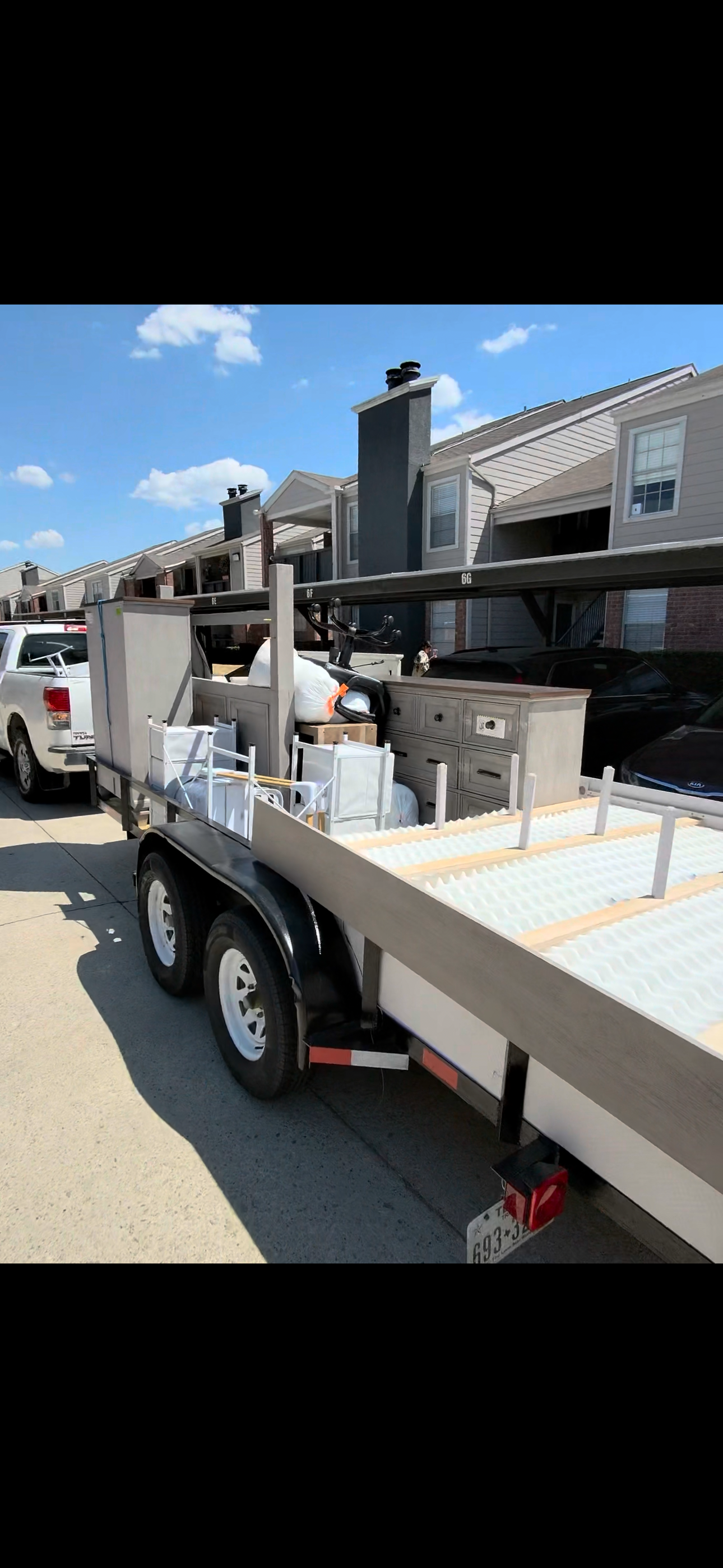 Trailer loaded with bedroom furniture outside an apartment complex