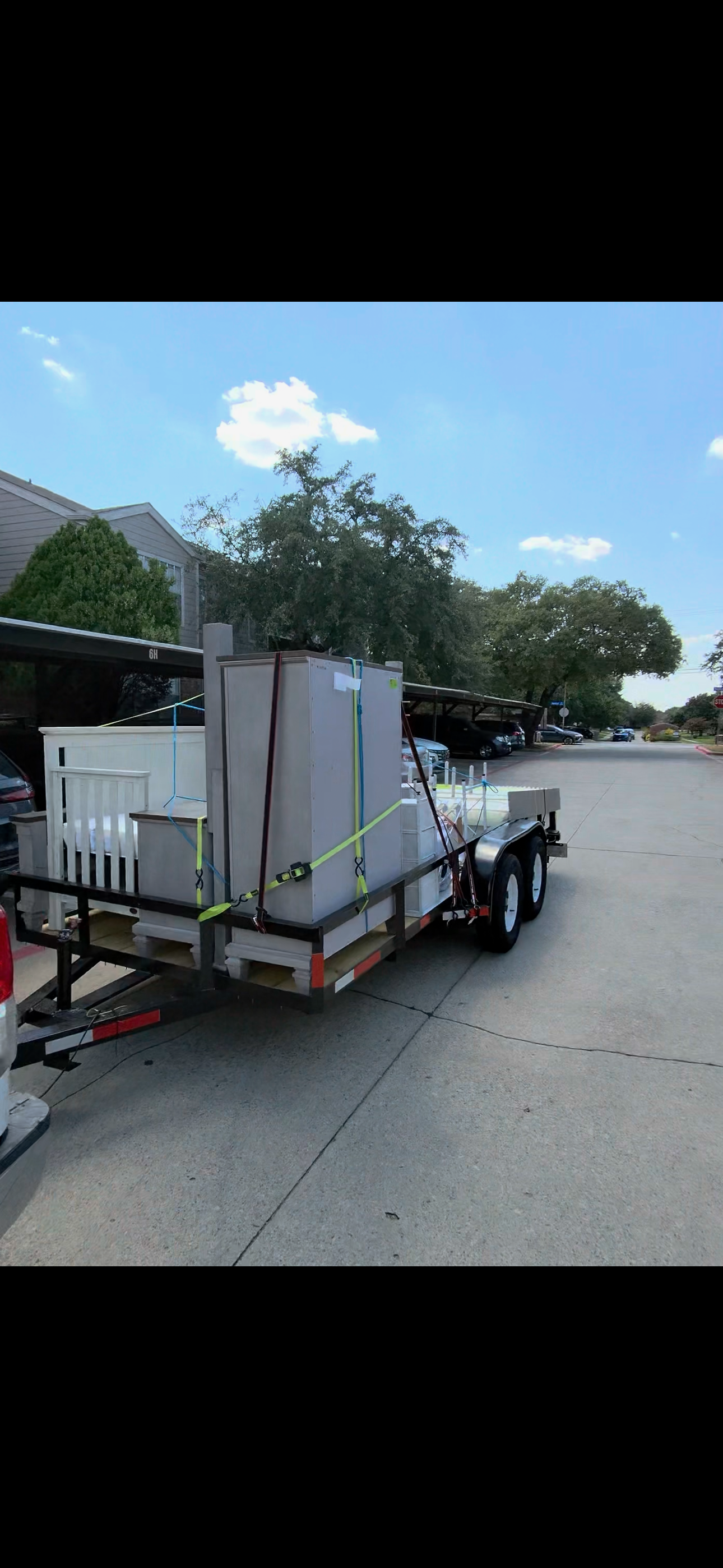 Dressers and bed frames strapped onto a trailer