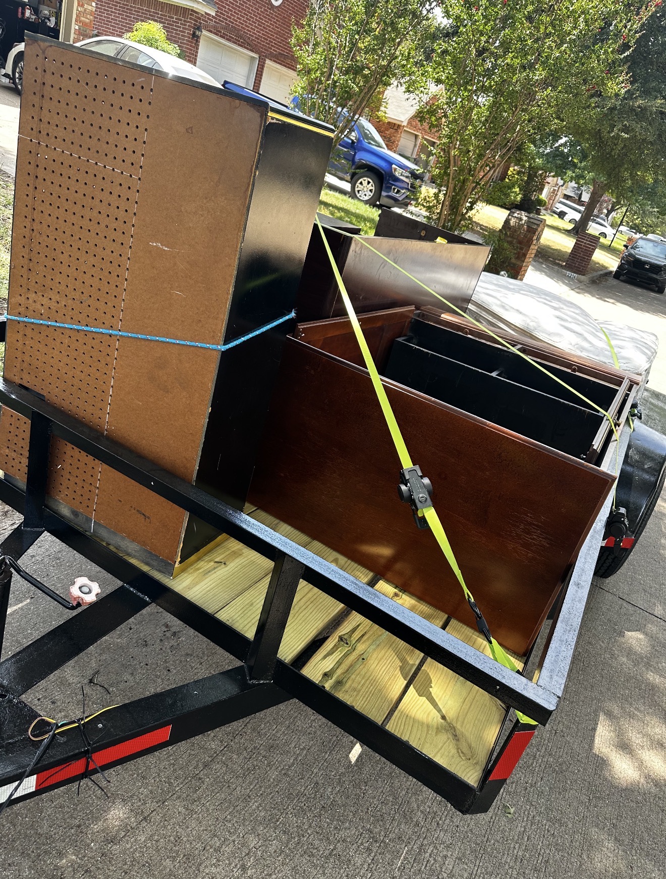 Wood furniture secured with straps on a hauling trailer